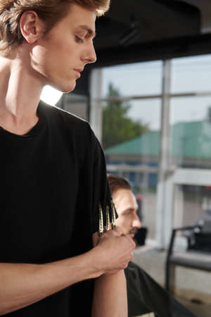 Portrait of a handsome man hairstylist working at barbershop.の写真素材