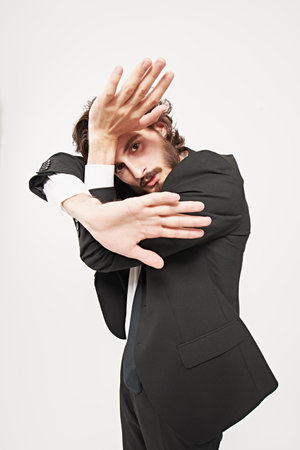 Fashion concept. Portrait of a handsome well-groomed man fashion model posing in motion at studio. White background.の写真素材