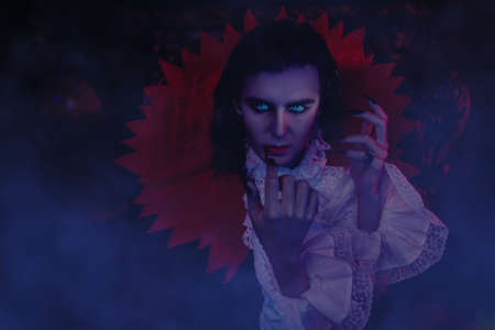 Scary vampire grins at a candle sneaking around the castle in the night in search of a victim. 19th century style. Halloween.の写真素材