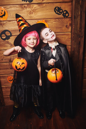 Happy Halloween! Funny cheerful kids in carnival costumes trick or treating on Halloween.の写真素材