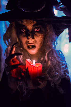 A scary ugly witch stands in an abandoned witch's den. Halloween. Scary tales.の写真素材