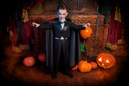 Halloween tales. Scary little boy in vampire costume is on Halloween night in the old castle.