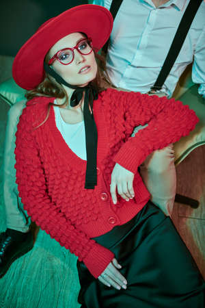 Portrait of a beautiful stylish  woman sitting on the floor leaning on her boyfriend's lap. Luxury apartment, dating. Glamorous lifestyle. Fashion shot.の写真素材