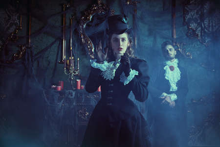 Vampires of the 19th century. Portrait of a beautiful young innocent lady terrified of being trapped in vampire's lair. Halloween.の写真素材