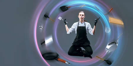 A professional chef cook in uniform is jumping up and down, surrounded by kitchen utensils flying around him. Master of his craft. Food and meals. Studio portrait.の写真素材
