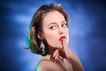 Beauty and jewelry. Close up portrait of a stunning brunette girl with evening makeup and gemstone...