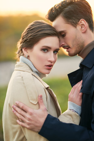 Portrait of passionately in love young couple in stylish autumn  clothes having a walk by the river at sunset. Love and relationship.の写真素材