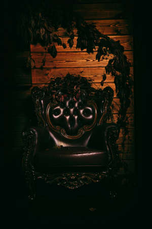 Portrait of a scary vintage empty armchair standing in a dark spooky room of a castle. Halloween. Day of the dead. Dia de los muertos.の写真素材