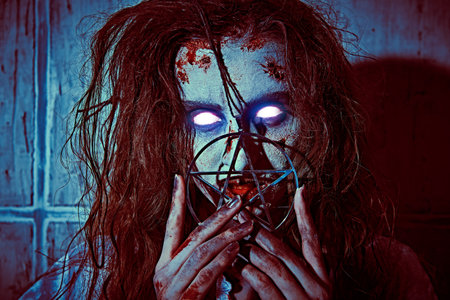 Devil possessed woman. Portrait of a bloodthirsty zombie woman with burning eyes stands against a...