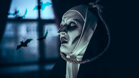 Portrait of a scary cursed nun standing in the abandoned chapel with a loop for hanging on her neck. Horrors. Halloween.の写真素材