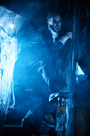 Portrait of a scary nobleman vampire with blood on his lips wandering around his gloomy old castle...