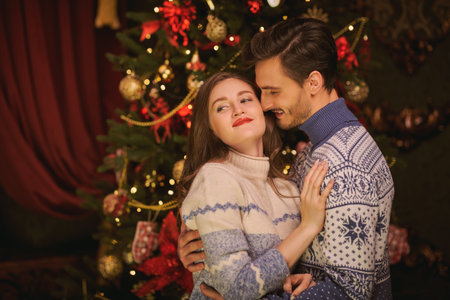 Merry Christmas and Happy New Year! Portrait of beautiful happy girl and young man hugging each...