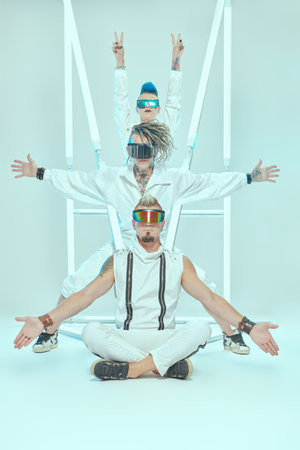Group of punk rock musicians in white overalls and cool cyber glasses pose at the studio in neon...