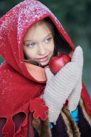Magical winter fairy tales. Portrait of a girl with blond hair, clear blue eyes, dressed in a warm...