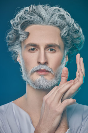 Divine man with beard and curly hair on a blue background. Art image of God. Roman and Greek...