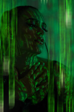 Cyber girl of the future. Portrait  of an attractive confident girl among light and shadows of the matrix. The matrix style.の写真素材