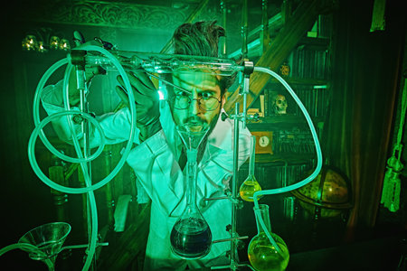 A crazy scientist doing experiments in his laboratory lit by a mysterious green light. Character of...