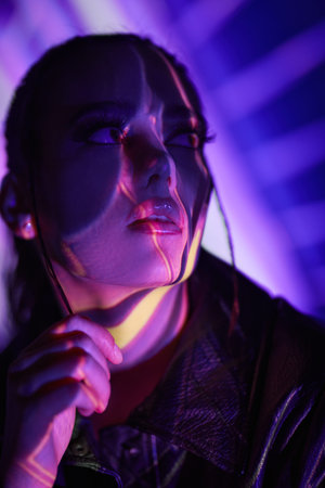 Futuristic style, beauty and fashion. Attractive brunette girl wearing a black leather jacket posing...