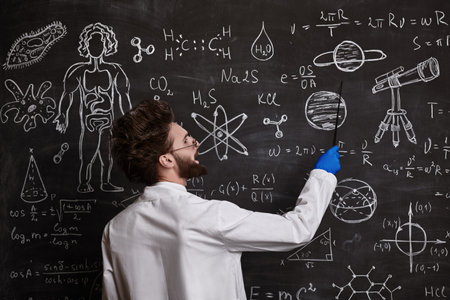 A smart enthusiastic scientist stands at the blackboard explaining scientific formulas and diagrams....
