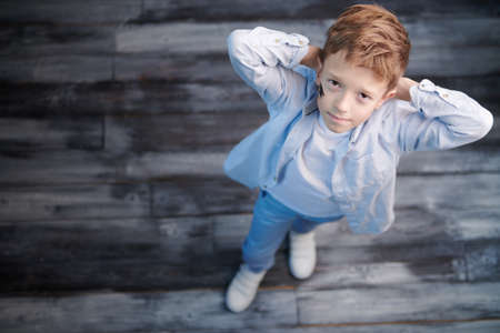 Kid's fashion. Trendy little boy posing in stylish casual clothes in a loft style room. Full length shot with copy space.の写真素材