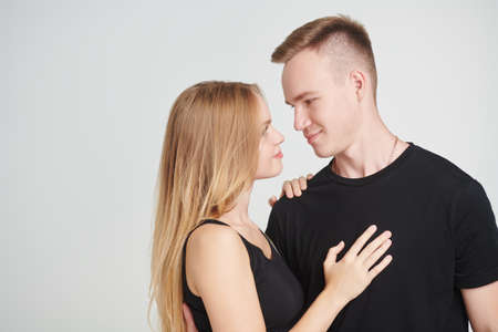 Love story. Portrait of a beautiful girl and handsome guy looking at each other with love. White background. Valentine's Day.の写真素材