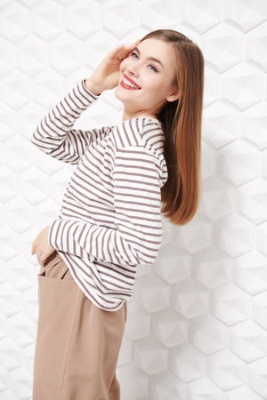 Happy people and emotions. Portrait of a beautiful fair-haired girl in casual clothes laughing joyfully in a white background.の写真素材