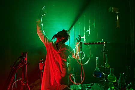 Triumph, a possessed scientist has succeeded in his experiments in his laboratory. Mysterious green and red lighting.の写真素材