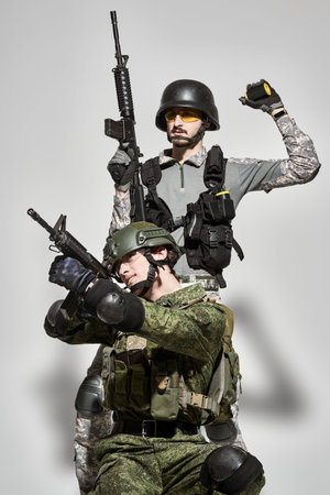 Military and war concept. Portrait of brave soldiers in Protective Combat Uniform with the guns in...