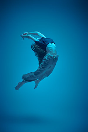Dance expression. Modern ballet dancer girl flies in jump. Contemporary ballet. Full-length studio...