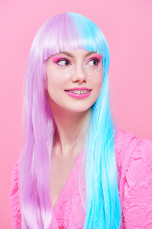Beautiful girl with colored purple-blue hair and bright pink makeup with shiny glitter freckles....