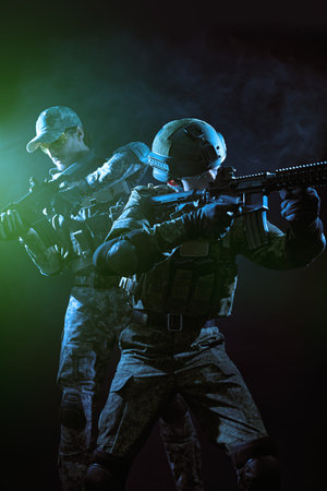 War and military concept. Portrait of brave soldiers in Protective Combat Uniform aiming with the...