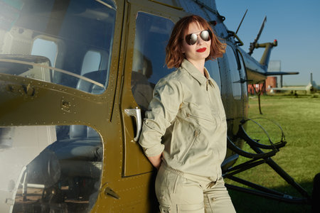 Portrait of an attractive professional woman pilot with bright red lips and black sunglasses...