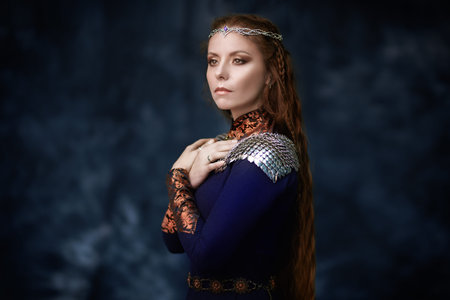 Fantasy world. Ancient legends. Portrait of a beautiful, majestic medieval queen on a dark background.の写真素材
