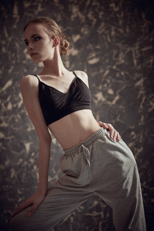 Portrait of a beautiful modern girl dancer posing in the studio on a grunge background. Contemporary...