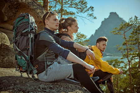 Active lifestyle, mountain tourism. Young backpackers enjoying the view of the valley from the top...