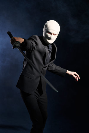 Business concept, Competitive wars.  A warrior businessman in a classic black suit, with a bandaged...