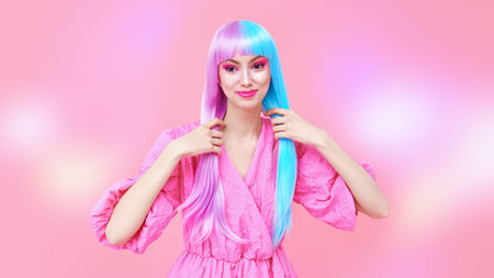 Cute girl with bright makeup and in colored violet-blue wig posing in stylish pink dress. Pink...