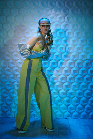 Beautiful female fashion model poses in trendy designer clothes and sunglasses on a tech background. High fashion. Haute couture summer style.の写真素材