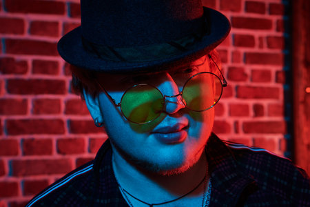 Rapper guy in a nightclub. Portrait of a plump man in modern clothes with stylish black hat and...