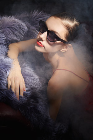 Luxury style in clothes and accessories. Portrait of an elegant brunette girl posing in fashionable...