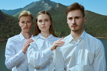 Business concept, teamwork. Three young people in white dress shirts stand together as a team...