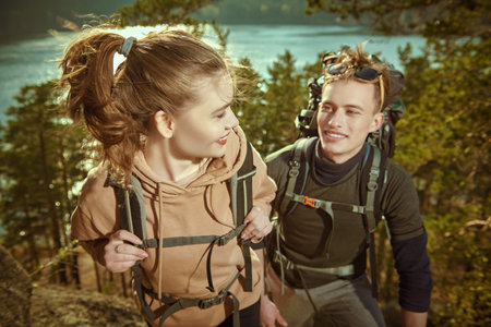 A couple of joyful backpackers hike in the mountains. Travel, active lifestyle, adventure. Summer...
