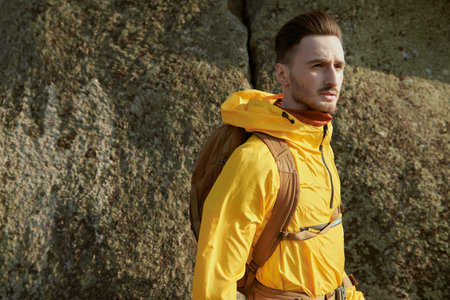 Portrait of a young man tourist with a backpack hiking in the mountains. Tourism, hiking. Summer...