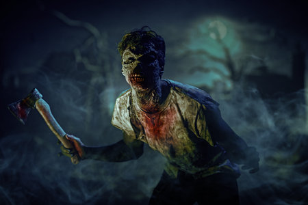 Halloween, horror. A terrible bloodthirsty zombie man stands in the night cemetery with an ax in his...