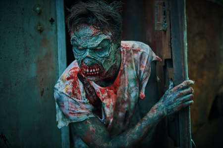 Zombie apocalypse. Terrible bloody zombie man in a ruined city. Halloween. Horror movie.の写真素材