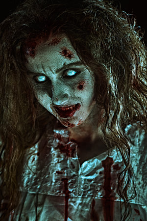 A disfigured bloody woman possessed by the devil looks to the camera with faded eyes and smiles....