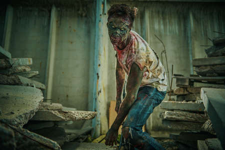 Horror movie. Zombie apocalypse. Disgusting bloodthirsty zombie man prowls the ruined city. Halloween.の写真素材