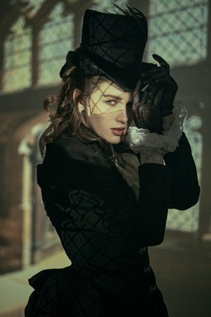 Fashion of the late 19th - early 20th century. Portrait of an elegant lady in a black dress and hat...