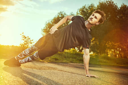An active young man is having a workout in the park at sunset. Sport and fitness. Active lifestyle.の写真素材