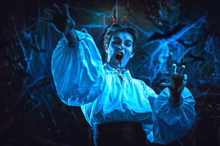 A cunning young vampire attacks his victim in an abandoned medieval castle. A novel about vampires. Halloween.の写真素材